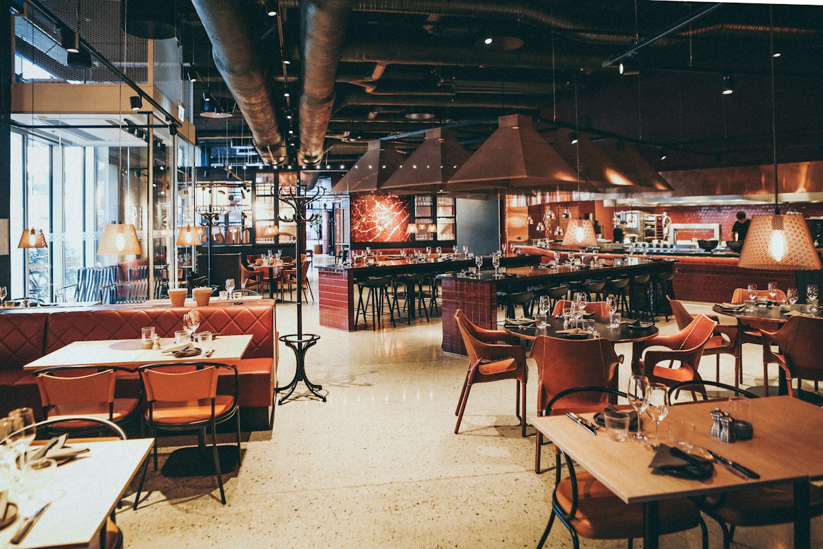 Tuğla duvar ve bakır detaylı geniş restoran iç mekânı